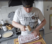 a man wearing a chef 's hat is cooking in a kitchen