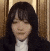 a close up of a woman 's face wearing a suit and tie .