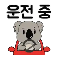 a cartoon koala bear is driving a red car with korean writing behind him