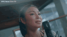 a woman singing into a microphone with the word oppo reno6 series on the bottom right