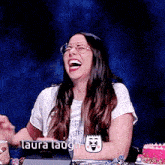a woman wearing glasses is laughing with the words laura laugh behind her