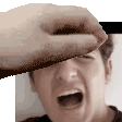a person is covering a man 's face with their hand while he screams .