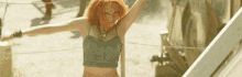 a woman with red hair wearing a green crop top
