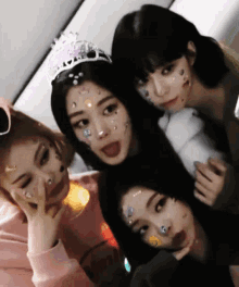a woman with a tiara on her head is surrounded by other girls