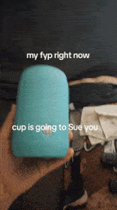 a person is holding a blue device that says " my fyp right now cup is going to sue you "