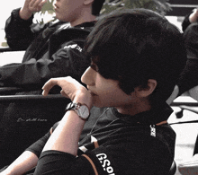 a man wearing a watch and a shirt that says g.so.
