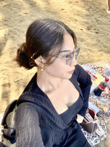 a woman sits on a blanket on the beach with a bottle of coca cola in the background