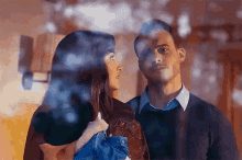 a man and a woman are looking into each other 's eyes .