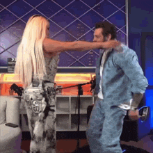 a man and a woman are dancing in front of a microphone and the woman has the letter s on her jeans