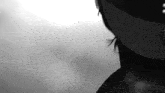 a black and white photo of a woman wearing a mask and earrings .