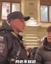 a man wearing a black jacket that says " eckar " on the sleeve