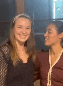 two women are posing for a picture together and smiling .