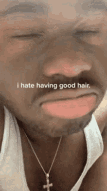 a man wearing a white tank top and a cross necklace says i hate having good hair ..