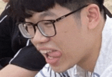 a man wearing glasses is making a funny face .