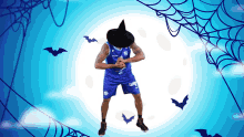 a basketball player wearing a witch hat is surrounded by bats and webs