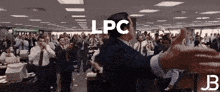 a man in a suit and tie stands in front of a crowd with the word lpc written on his back
