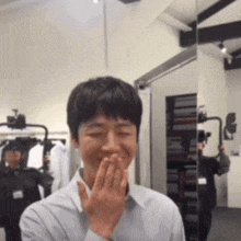 a man is covering his mouth with his hand in a room