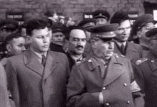 a black and white photo of a group of men in suits and hats