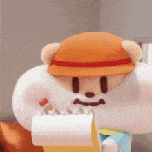 a teddy bear wearing an orange hat holds a roll of toilet paper
