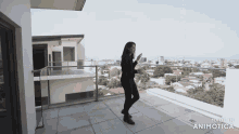 a woman is standing on a balcony with the words made in animotica on the bottom