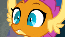 a close up of a cartoon pony with blue eyes