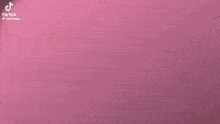 a man is standing in front of a pink wall with the word prison in yellow letters .