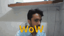 a man in a blue shirt with the word wow on his face