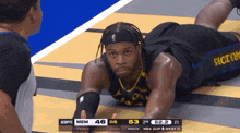 a basketball player is laying on the floor during a game against the warriors