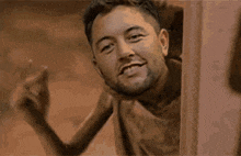 a man with a beard is standing in front of a door .