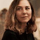 a woman with a serious look on her face is wearing a black sweater