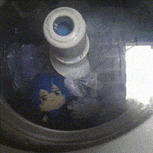 a doll with blue hair is sitting inside of a washer