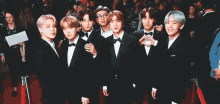 a group of young men in suits and bow ties are posing for a picture .