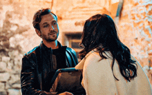 a man and a woman are standing next to each other looking at each other