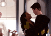 a man and a woman are standing next to each other in a room .