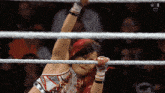 a woman in a wrestling ring with a w logo on the bottom