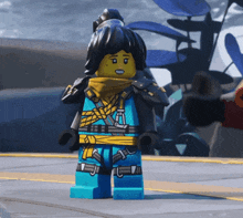 a lego figure with black hair and a yellow scarf