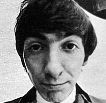 a black and white photo of a young man in a suit and tie .