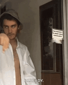 a shirtless man pointing at a sign that says already