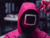 a person wearing a pink jacket and a square mask is holding a gun .