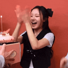 a woman stands in front of a birthday cake with a candle