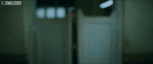 a blurry picture of a person standing in a doorway with xtoms written in the corner