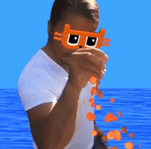 a man with a cat mask on his face is standing in front of a body of water