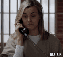a woman is talking on a phone with a netflix logo in the corner