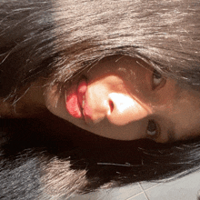 a close up of a woman 's face with the sun shining on her hair