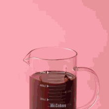 an ice cream cone is being poured into a measuring cup that says mr.cakes on it