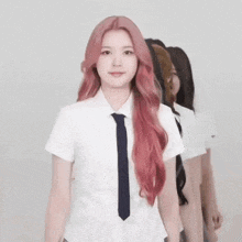 a girl with pink hair is wearing a school uniform and a tie .