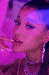 ariana grande is wearing a necklace and hoop earrings
