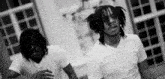a black and white photo of two men wearing white tshirts