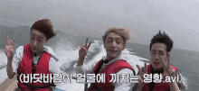 a group of young men are sitting on a boat in the ocean and giving peace signs .