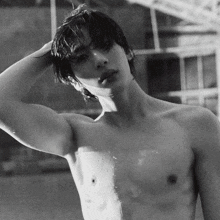 a man without a shirt has his hand on his head